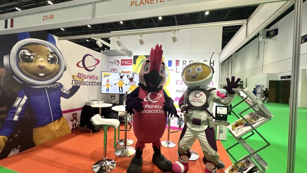 Stand de Planète Mascottes au salon DEAL Dubaï 2025, présentant des mascottes personnalisées aux visiteurs internationaux.